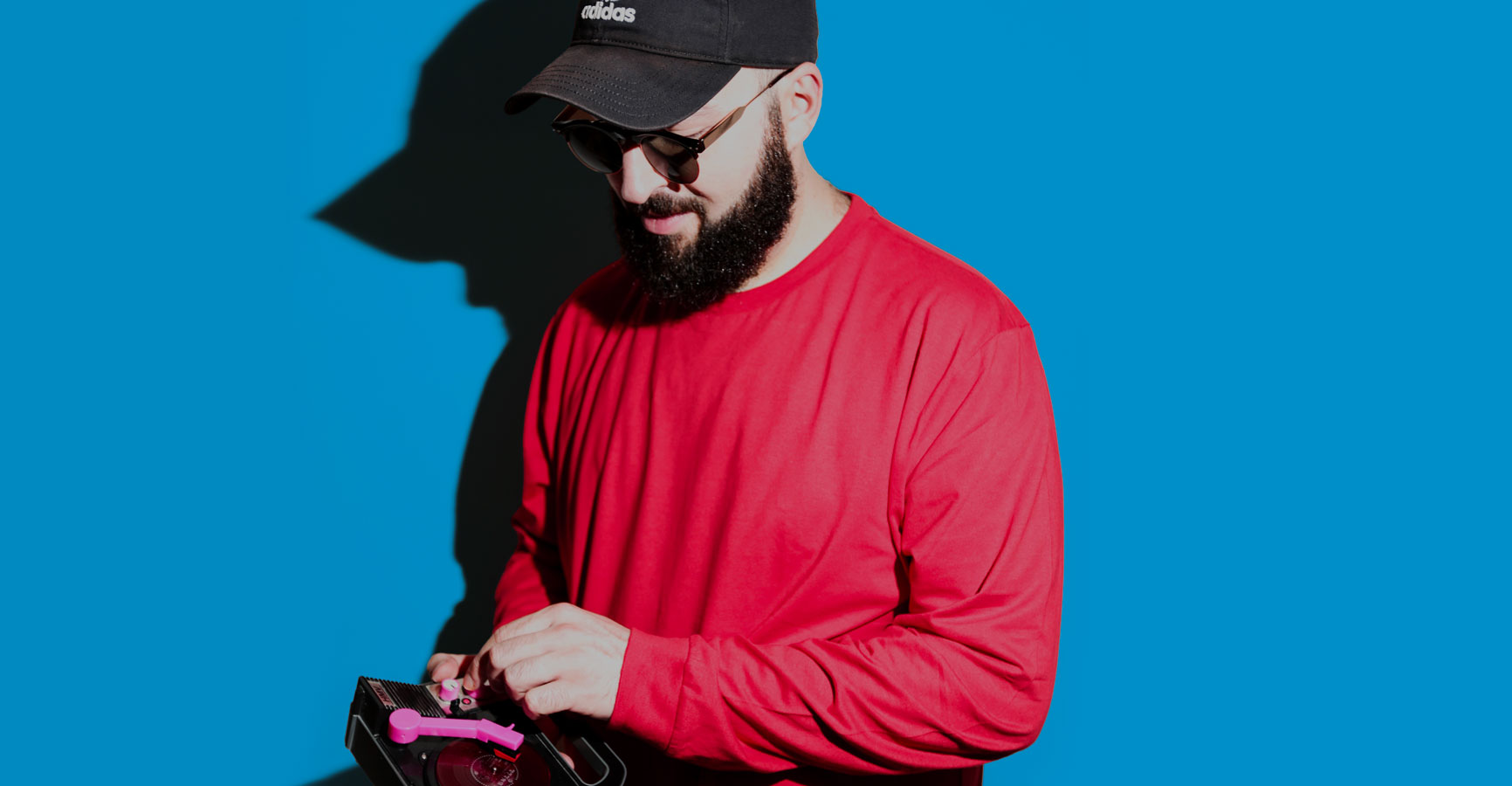 DJ Color con un giradischi portatile su sfondo azzurro